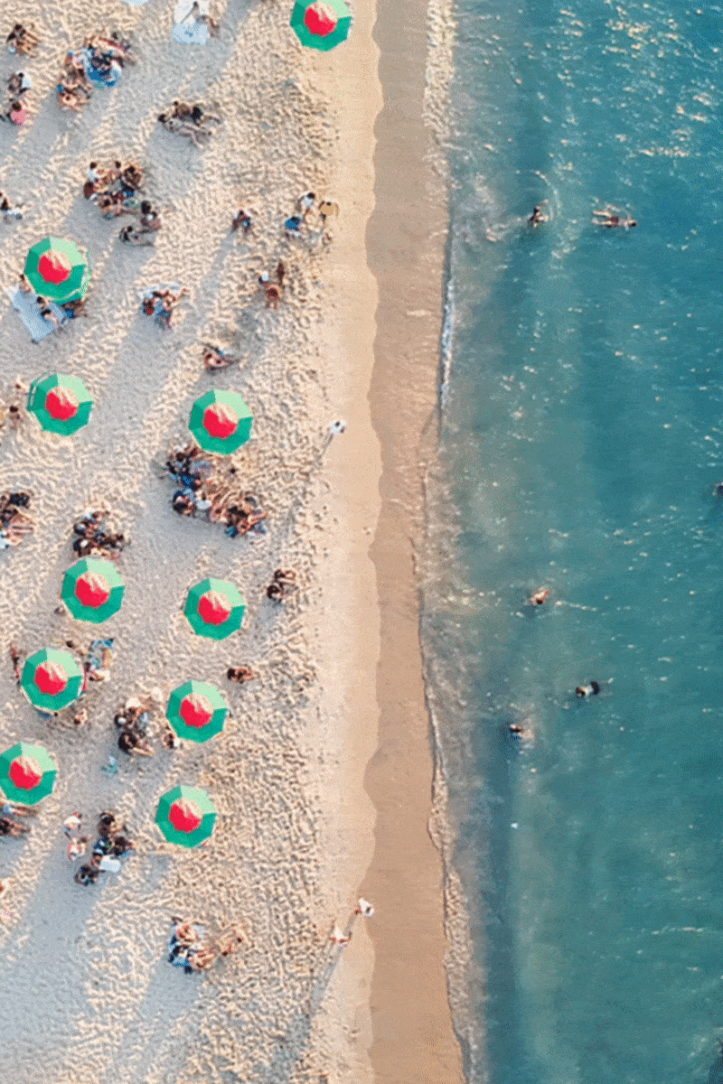 An overhead image the beach with spinning umbrellas.