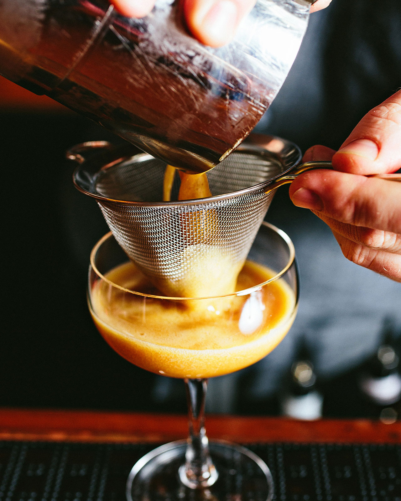 An up-close image of an espresso martini being made.